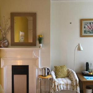 a living room with a chair and a fireplace at Arun Sands Rooms in Littlehampton