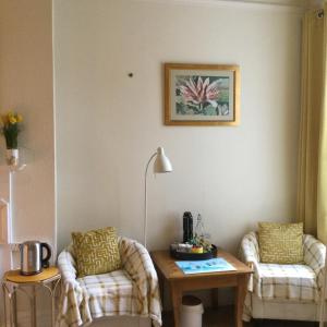 a living room with two chairs and a table at Arun Sands Rooms in Littlehampton