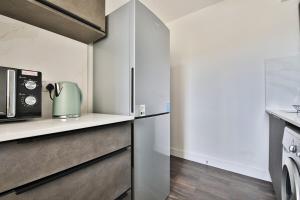 eine Küche mit Kühlschrank und Mikrowelle in der Unterkunft Centrally Located 2Bed Flat With Balcony & Parking in Cardiff
