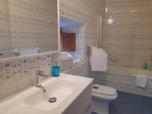 a bathroom with a sink and a toilet and a mirror at Casa Cotiellu in Llanes