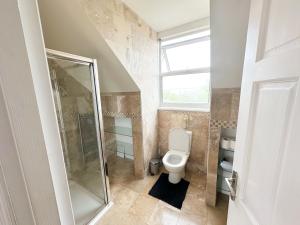 a bathroom with a toilet and a glass shower at 11 Guests - 6min Drive to the Wembley Stadium in London