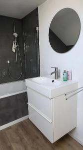a white bathroom with a sink and a mirror at Apartment Zum Wohlfühlen in Sulz am Neckar