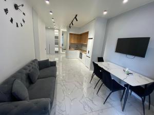 a living room with a couch and a table at A&M Apartments White - New Building in Yerevan