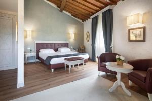 a bedroom with a bed and a couch and a table at LHP Certaldo Resort in Certaldo +63 photos