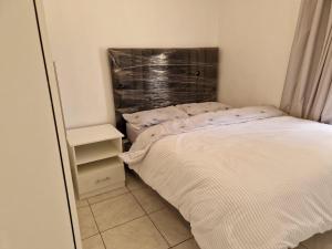 a small bedroom with a bed and a mirror at Cosy Harare Haven Cottage in Harare