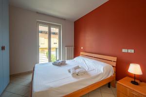 a bedroom with a bed with two towels on it at Happy Central Apartments in Alba