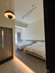 a bedroom with two beds and a mirror at Miruku in Taitung City