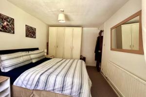 a small bedroom with a bed and a mirror at Oldham Bungalow Retreat: 2BD Peaceful Comfort in Lees