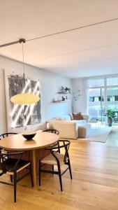 a living room with a table and a couch at Heart of Aarhus, modern apartment and paid parking nearby in Aarhus