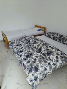 two twin beds in a room with a black and white comforter at Guest House 369 in Jajce