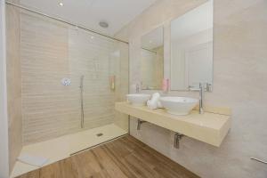ein Badezimmer mit zwei Waschbecken und einer Dusche in der Unterkunft Villa Jade II in Can Picafort