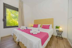 ein Schlafzimmer mit einem großen Bett mit rosa und weißen Kissen in der Unterkunft Villa Jade II in Can Picafort