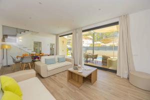 ein Wohnzimmer mit einer Couch und einem Tisch in der Unterkunft Villa Jade II in Can Picafort