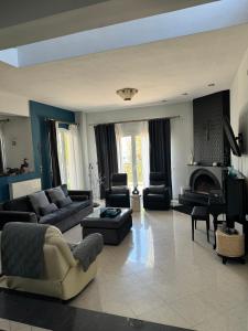 Una gran sala de estar con sofás y chimenea. en E L urban villa., en Epanomí