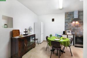 a kitchen with a table with a green table cloth at A Casa dos Avós in Pêra