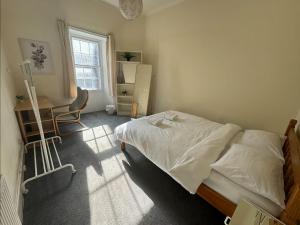 a bedroom with a bed and a desk and a window at Edinburgh Central Cozy Flat in Edinburgh