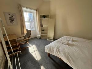 a bedroom with a bed and a desk and a chair at Edinburgh Central Cozy Flat in Edinburgh +8 photos