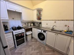 a kitchen with a sink and a washing machine at Edinburgh Central Cozy Flat in Edinburgh
