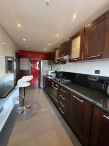 une cuisine avec des armoires en bois et un tabouret à l'intérieur dans l'établissement GUELIZ, majorelle, Beautiful apartment with large terrace, à Marrakech