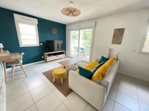 a living room with a couch and a table at Joli appartement rénové La Rochelle in La Rochelle