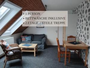a living room with a couch and a table at Haus Krabbe Apartments, zentral gelegen zwischen Bremerhaven und Cuxhaven, Hunde kostenfrei willkommen, hauseigene kostenfreie Parkplätze, Unterstellmöglichkeit für Fahrräder und E-Bikes in Wremen