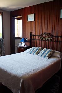 a bedroom with a bed with a wooden wall at Casa de Aldea El Valle in Buelna