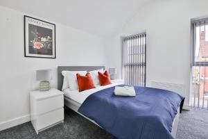 カーディフにあるModern 2 Bedroom House in Central Cardiffの白いベッドルーム(オレンジ色の枕が付くベッド付)