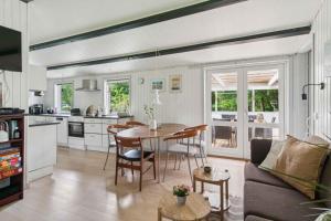 une cuisine et un salon avec une table et des chaises dans l'établissement Lovely Cottage Close To Beach And Nature, à Yderby