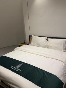 a bed with a green and white blanket on it at The Woodpecker - Glamps & Resorts in Tāl