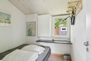 une petite chambre avec un lit et une fenêtre dans l'établissement Lovely Cottage Close To Beach And Nature, à Yderby