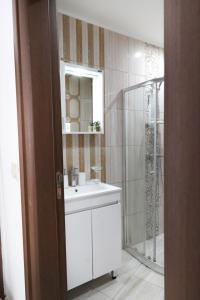 a bathroom with a white sink and a shower at Stylish Paradiso Apartment 206 in Nesebar