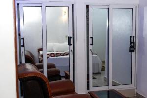 ein Zimmer mit Spiegeln und ein Schlafzimmer mit einem Bett in der Unterkunft New Hotel Sossa in Cotonou