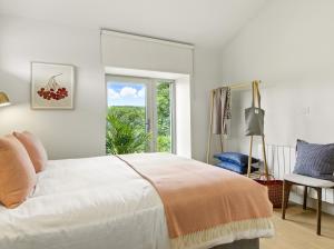 a bedroom with a bed and a window and a chair at The Loft at the Warehouse in Clifden