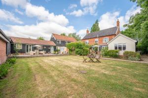 un patio trasero de una casa con un patio sidx sidx en Thyme Shepherds Hut Boundary Farm, Framlingham, en Woodbridge