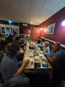 Un grupo de personas sentadas en una mesa comiendo comida en Drover's inn, en Moora