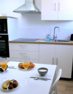a kitchen with a table with two glasses of orange juice at Appt du Phare, 1 ch, proche port et plage de Calais in Calais