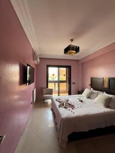 - une chambre avec un grand lit aux murs roses dans l'établissement GUELIZ, majorelle, Beautiful apartment with large terrace, à Marrakech