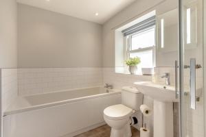 a white bathroom with a tub and a toilet and a sink at 2 Bed in Dalston oc-g32205 in Dalston +17 photos
