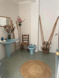 a bathroom with a toilet and a sink and a table at La Casa de Tente in Priego de Córdoba