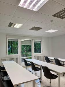 an empty office with tables and chairs and windows at Miresibilbao - Residencia Universitaria in Bilbao