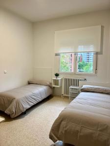 a bedroom with two beds and a window at Miresibilbao - Residencia Universitaria in Bilbao