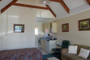 a bedroom with a bed and a couch and a kitchen at Bavarian Motel in Invercargill