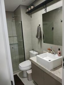 a bathroom with a sink and a toilet and a mirror at FLAT BEACH CLASS SUMMEr PORTO DE GALINHAS in Porto De Galinhas