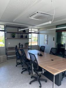 an office with a large wooden table and chairs at FLAT BEACH CLASS SUMMEr PORTO DE GALINHAS in Porto De Galinhas +16 photos