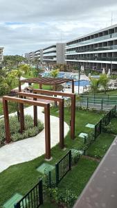 a wooden bench in a park next to a building at FLAT BEACH CLASS SUMMEr PORTO DE GALINHAS in Porto De Galinhas