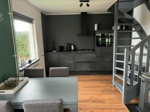 a kitchen with a table and a staircase in a room at Huisje Meerweg in Rohel