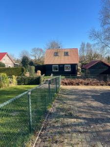 a house with a fence in front of it at Huisje Meerweg in Rohel