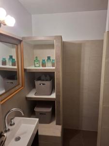 Un baño con lavabo y ducha con botellas verdes. en Colon Apartment, en Mendoza