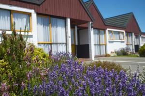 a large building with flowers in front of it at Bavarian Motel in Invercargill