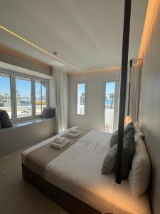 a bedroom with a large bed with windows at Tuck Inn in Larnaca